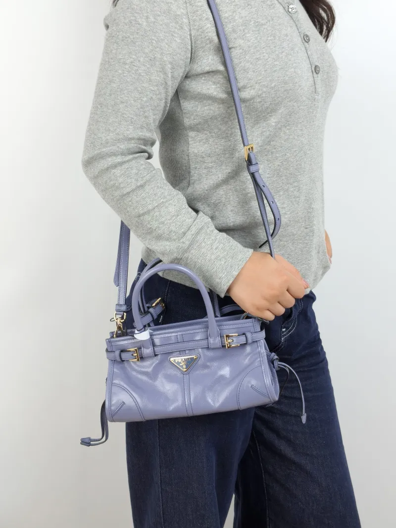 PRADA Top Handle Bag Bonnie Soft Lux Blue Waxed Leather Mini 23.5 × 9 × 12 cm — on-model view 2 of 3