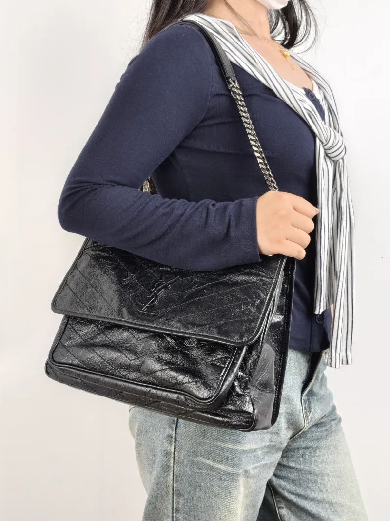 SAINT LAURENT Crossbody Bag Niki Black Calfskin Large 32 × 9 × 23 cm — on-model view 1 of 2