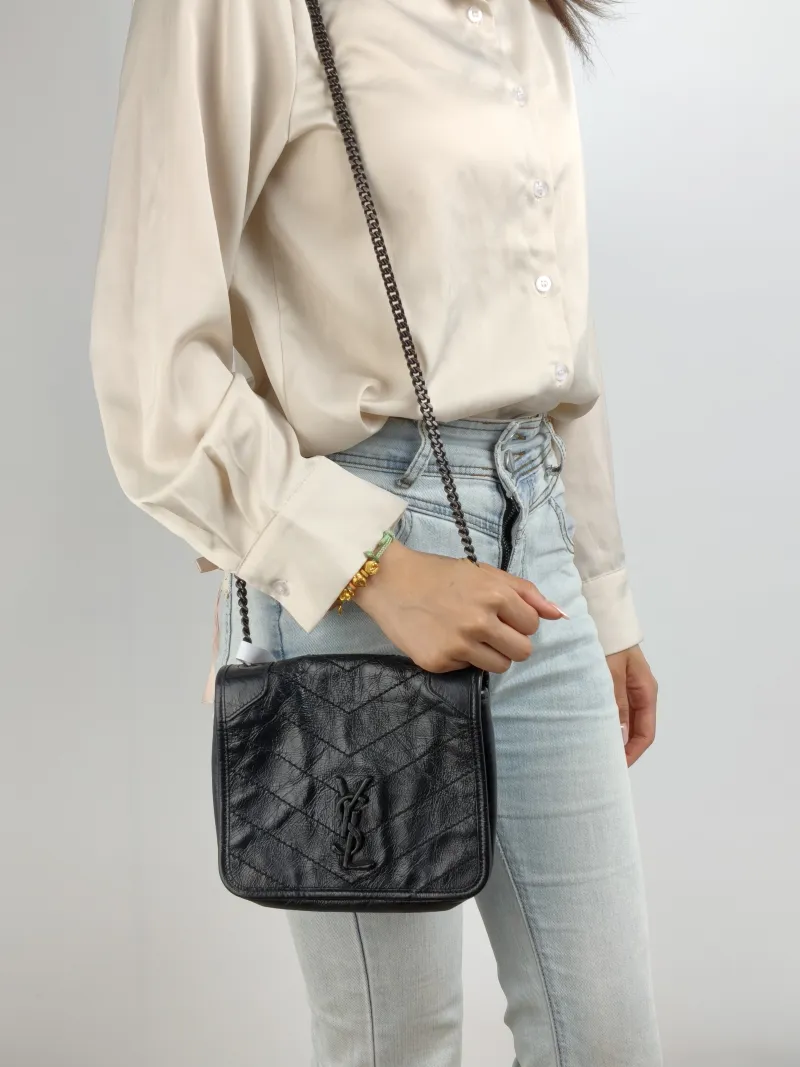 SAINT LAURENT Crossbody Bag Niki Chain Bagwoc Black Waxed Leather Calfskin Mini 19 × 5 × 16 cm — on-model view 1 of 2
