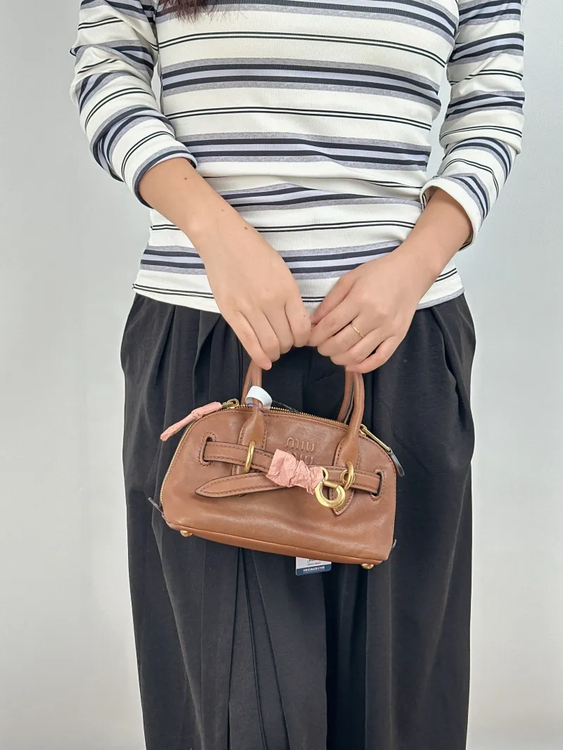Miumiu Top Handle Bag Aventure Top Handle Bag SL ambskin Mini 21 × 8 × 13.2 cm — on-model view 2 of 2