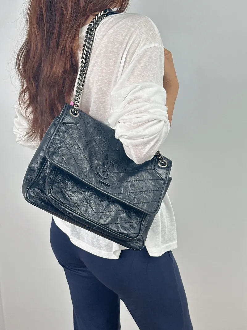 SAINT LAURENT Crossbody Bag Niki Black Waxed Leather Calfskin Medium 28 × 8.5 × 20 cm — on-model view 1 of 2