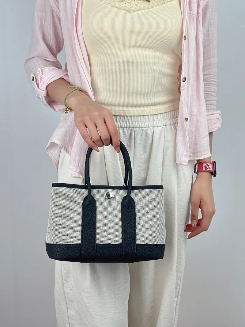 Hermès Top Handle Bag Neo Garden 23 Mini Black · Beige Canvas · Negonda Calfskinmini23 × 10 × 16 cm — on-model view 1 of 2