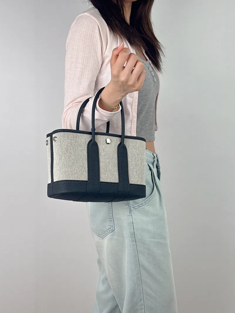 Hermès Top Handle Bag Neo Garden 23 Mini Black · Beige Canvas · Negonda Calfskin Mini 23 × 10 × 16 cm G — on-model view 1 of 2