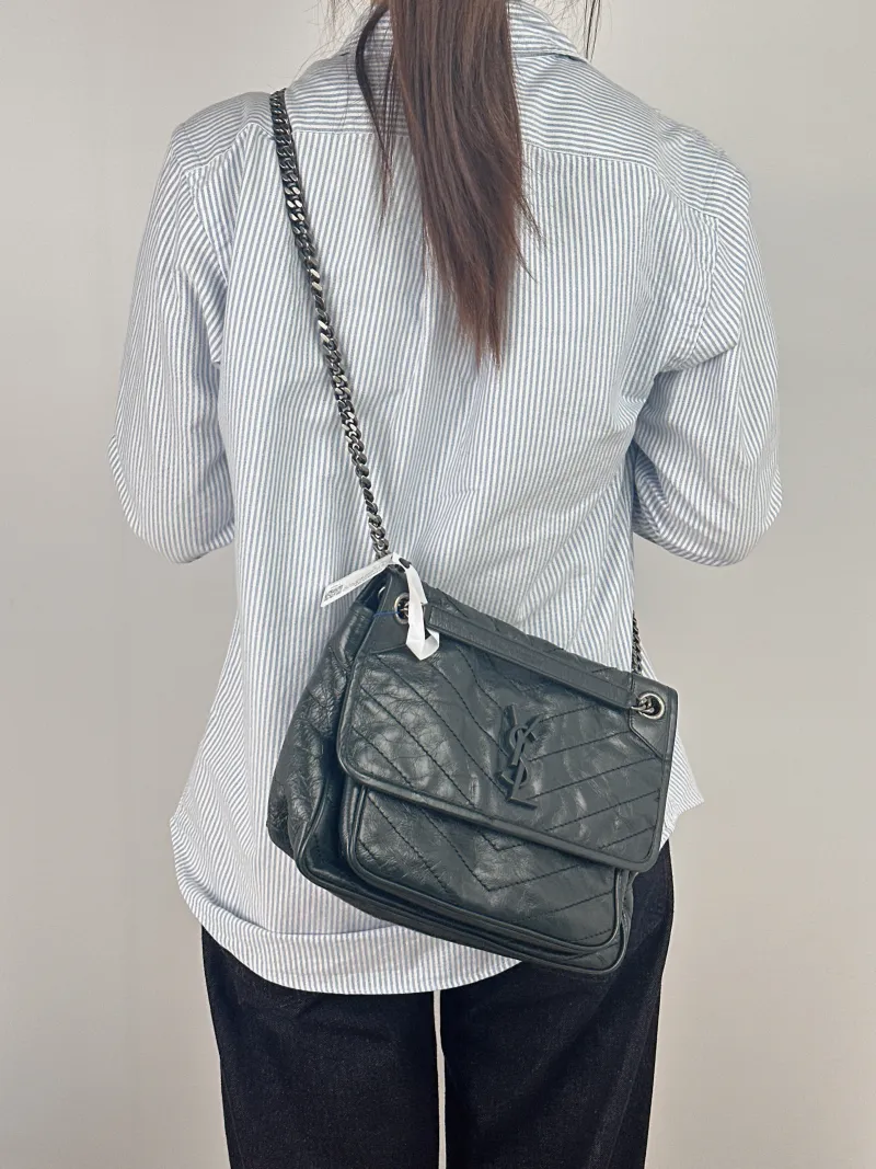 SAINT LAURENT Crossbody Bag Niki Green Waxed Leather Medium 28 × 8.5 × 20 cm — on-model view 1 of 2