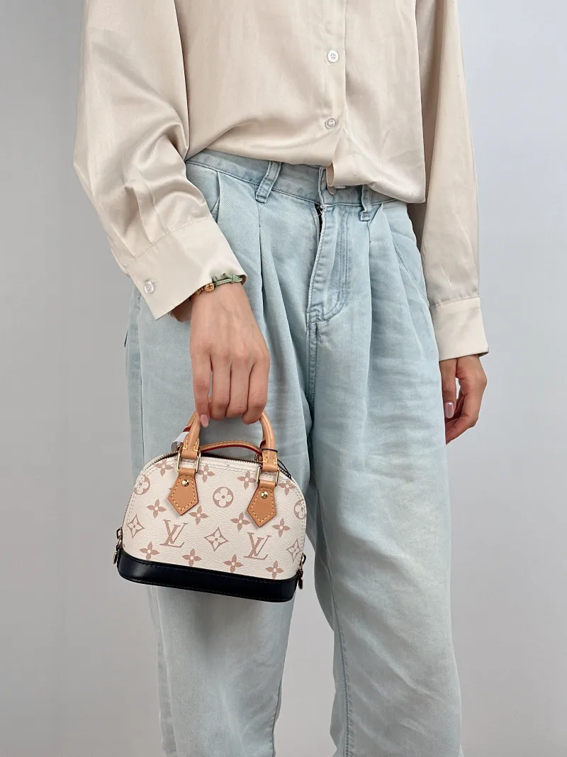 Louis Vuitton Crossbody Bag Alma Nano · Black PVC nano 18 × 8 × 12 cm — on-model view 1 of 2