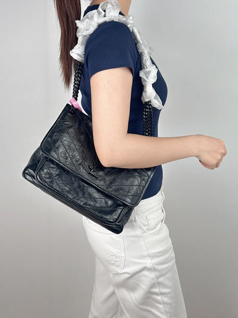SAINT LAURENT Crossbody Bag Niki Black D Waxed Leather Calfskin Medium 28 × 8.5 × 20 cm — on-model view 1 of 2