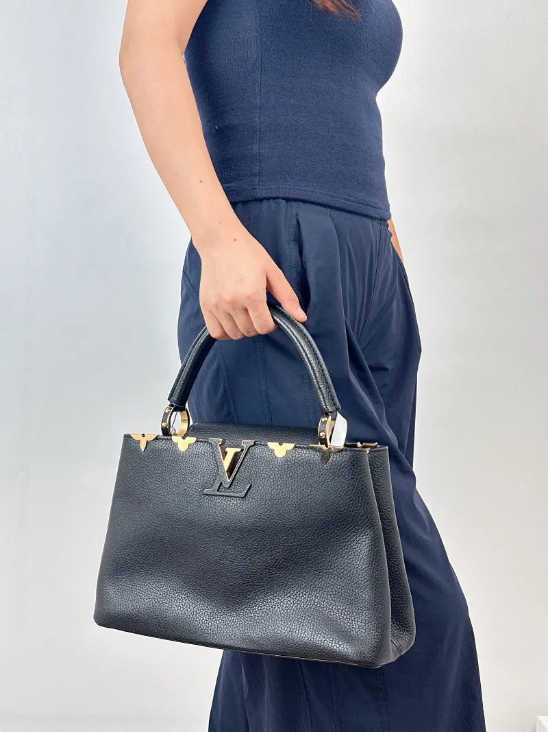 Louis Vuitton Top Handle Bag Capucines Black · Calfskin Medium31.5 × 11 × 20 cm — on-model view 1 of 2