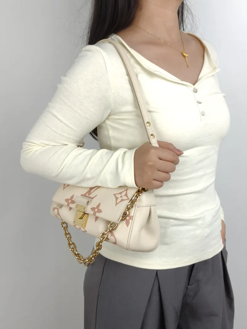 Louis Vuitton Crossbody Bag Favorite White · Pink Empreinte Embossed Calfskin Medium 24 × 9 × 14 cm — on-model view 1 of 3
